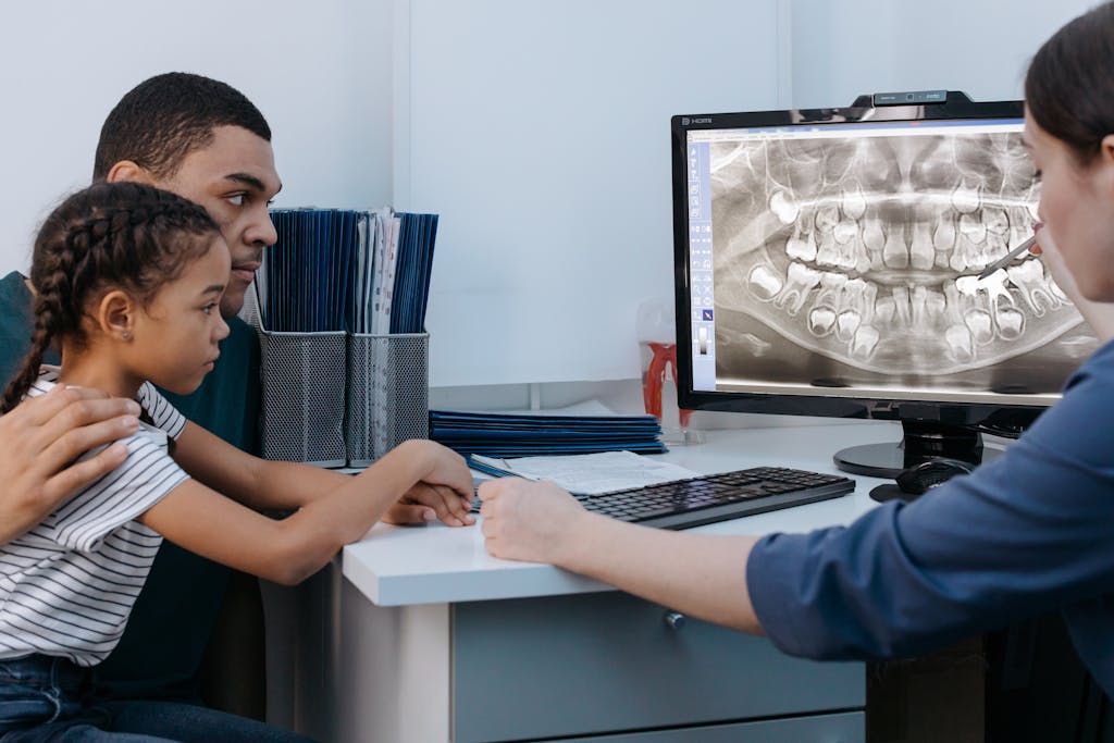 A Man and a Girl Having a Dental Consultation with a Dentist