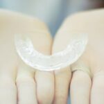 A Clear Retainer on a Person's Hands Wearing Gloves
