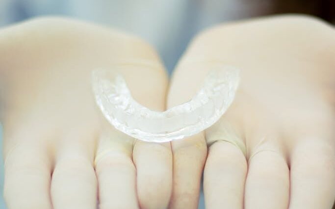 A Clear Retainer on a Person's Hands Wearing Gloves